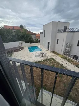 Pogled sa terase na dvorište sa bazenom i okolne zgrade. - image 3