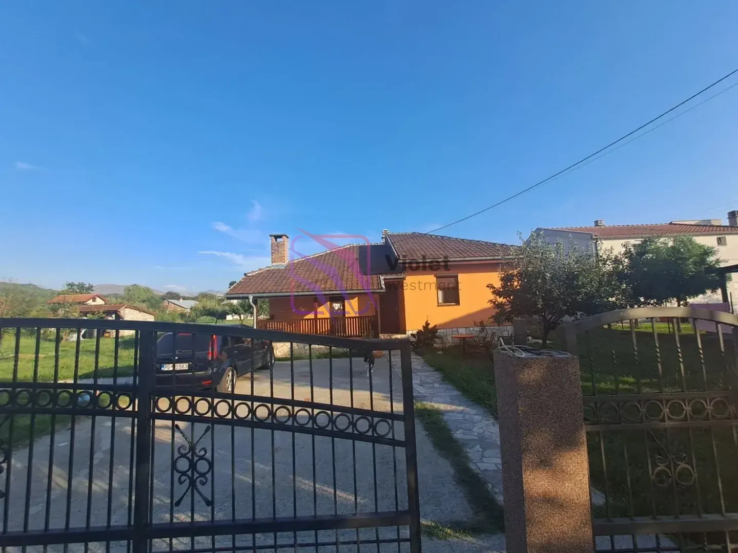 Pogled na dvorište i spoljašnjost kuće sa kapijom.