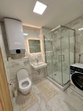 Moderno opremljeno kupatilo sa tuš kabinom i veš mašinom. - image 5