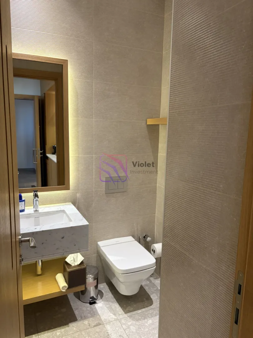 Moderne kupatilo sa umivaonikom, ogledalom i WC šoljom.