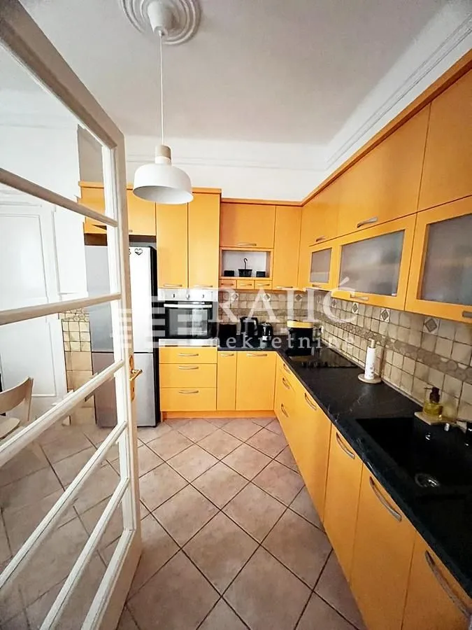 Yellow kitchen with cabinetry and black countertops.