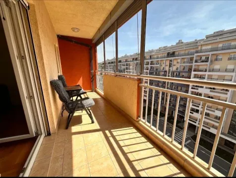 Natkriveni balkon sa staklenom ogradom i pogledom na okolne zgrade. - image 5