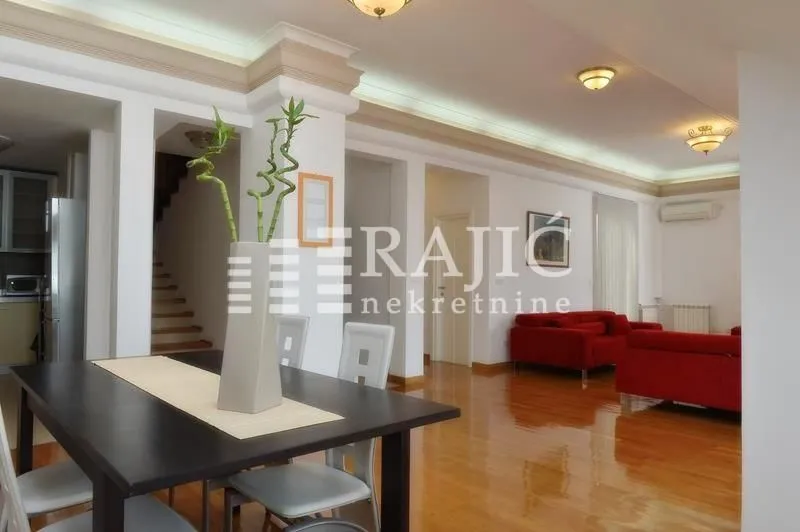 Spacious living room with a dining area and parquet flooring.