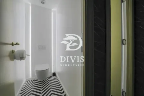 Small bathroom with white walls, a toilet, and black-and-white floor tiles. - image 17