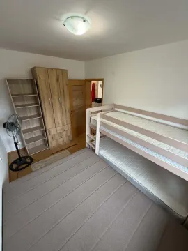 Bedroom with a bunk bed, wardrobe, and shelves. - image 9