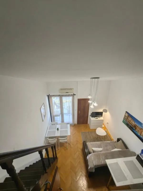 Pogled odozgo na dnevni boravak sa trpezarijom i stepeništem.