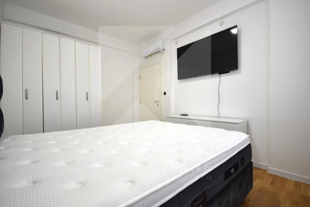 Bedroom with a double bed, built-in wardrobe, and wall-mounted TV.