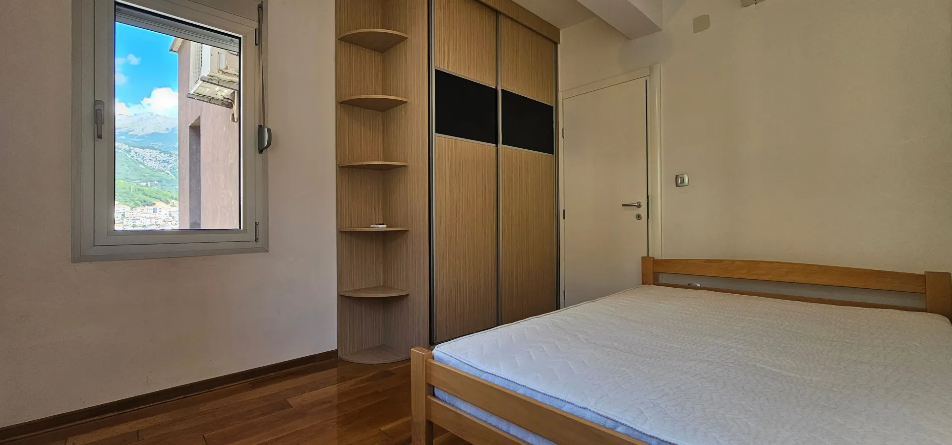 Bedroom with a double bed, fitted wardrobe, and a window with a view.