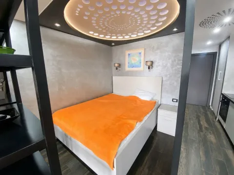 Furnished bedroom with a double bed, nightstand, and decorative ceiling. - image 5