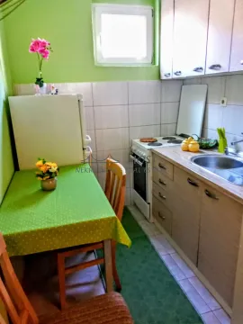 Manja kuhinja sa trpezarijskim stolom i zelenim stolnjakom. - image 6