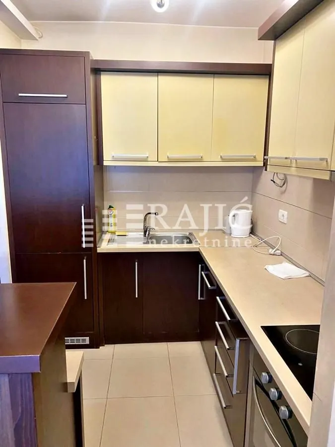 Smaller kitchen with dark wooden cabinets and built-in appliances.