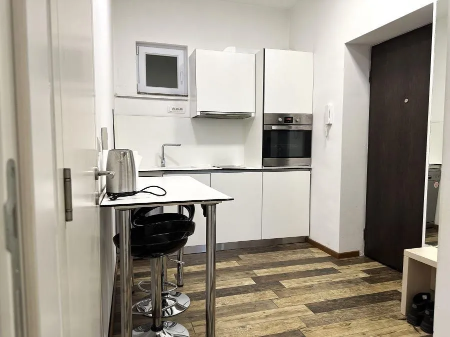 Smaller white kitchen with a dining table and chairs.
