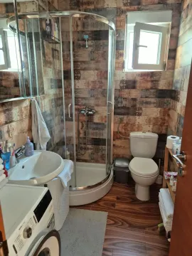 Compact bathroom with a shower cabin, sink, and toilet. - image 22