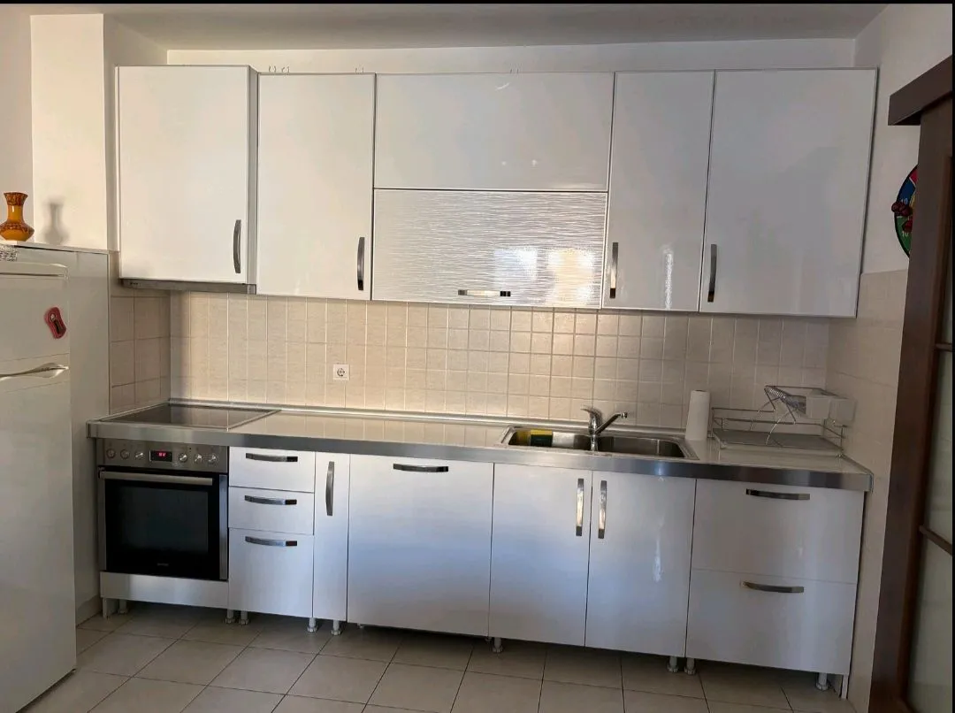 White kitchen with built-in appliances and a sink.