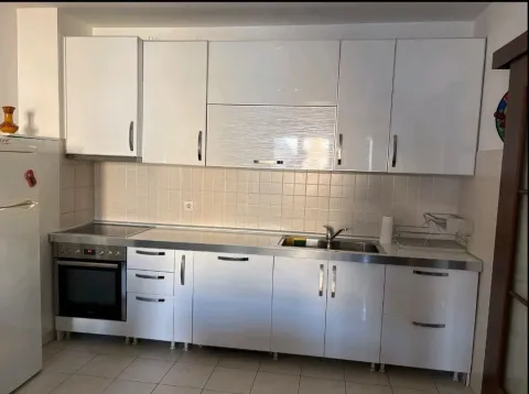 White kitchen with built-in appliances and a sink. - image 2