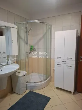 Kupatilo opremljeno tuš kabinom, umivaonikom i belim kupatilskim ormarićem. - image 16
