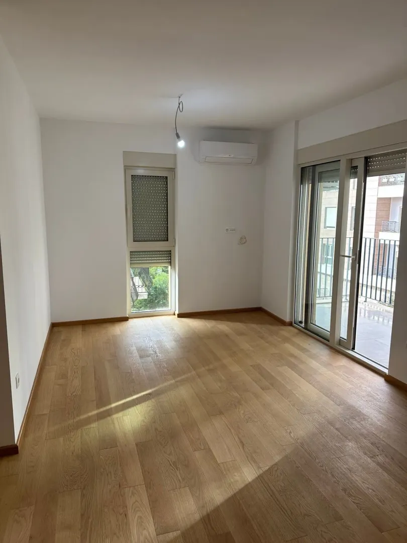 Empty room with parquet flooring and access to the terrace.