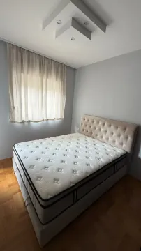 Bedroom with a double bed and a window covered by a curtain. - image 13