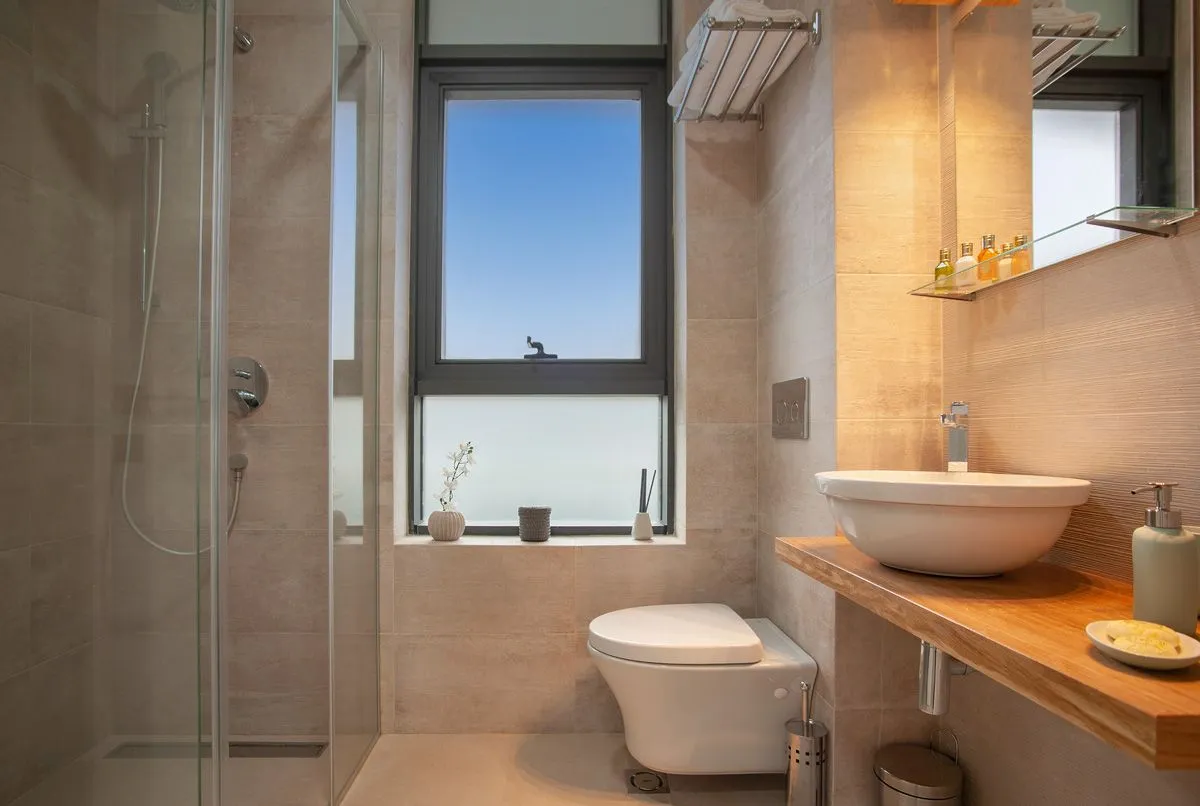 Modern bathroom with a shower enclosure and a wooden washbasin shelf.