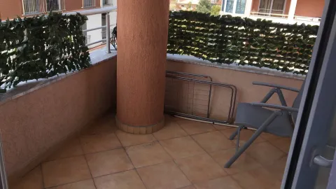 Spacious terrace with tiled floor and decorative green screen. - image 8