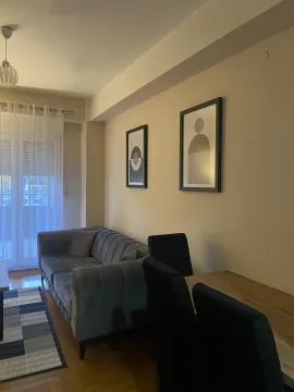 Living room with a grey sofa, dining table, and wall art. - image 10