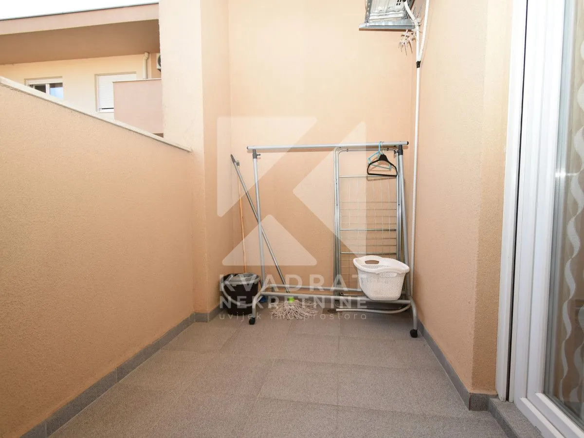 Manji balkon sa stalkom za sušenje veša i opremom za čišćenje.