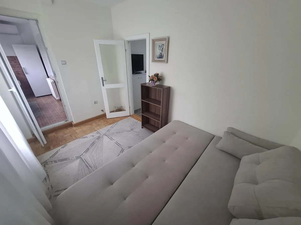 Living room with a sofa and view of interior doors and hallway.