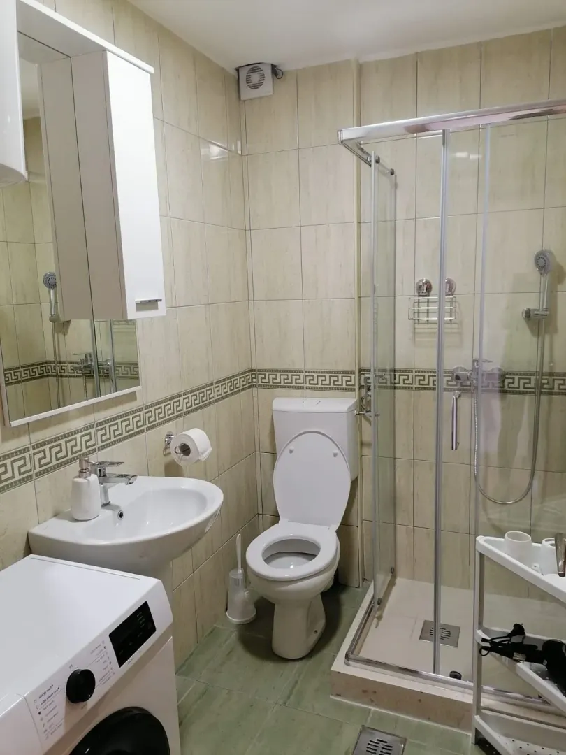Kupatilo opremljeno tuš kabinom, umivaonikom i WC šoljom.