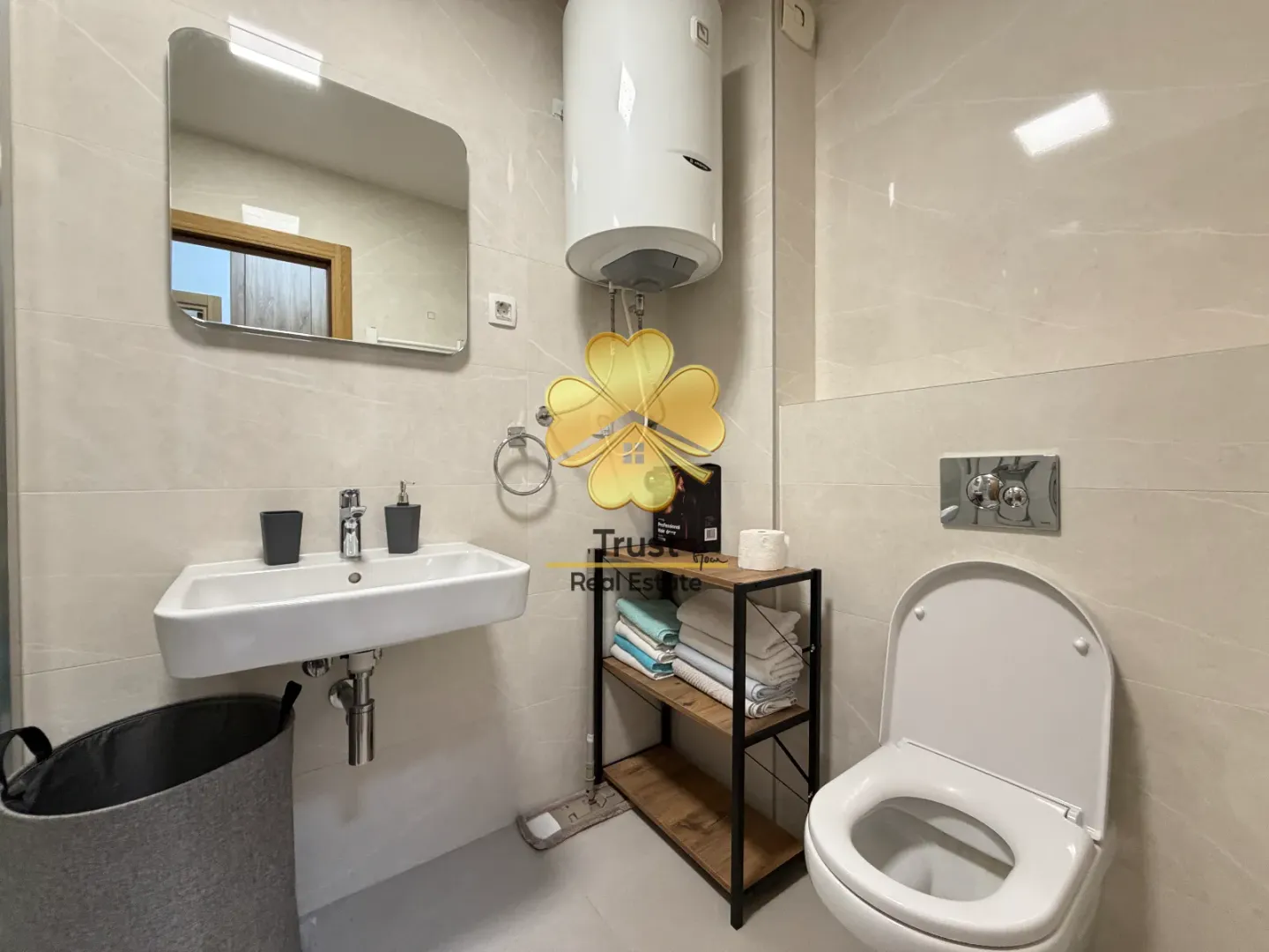 Modernly equipped bathroom with a sink, toilet, and storage shelving.