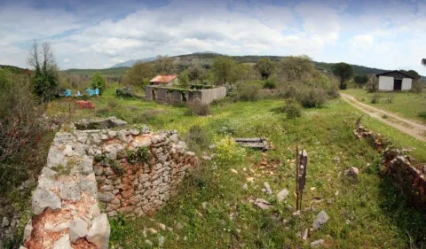 Pogled na prostrano zemljište sa ruševinama starih kamenih objekata i zelenilom. - image 6