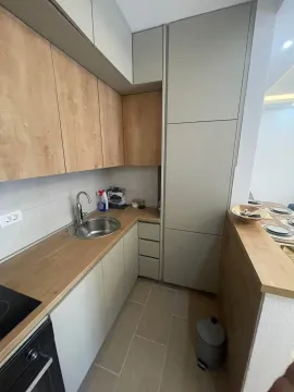 Small kitchen with wooden elements and a sink. - image 12