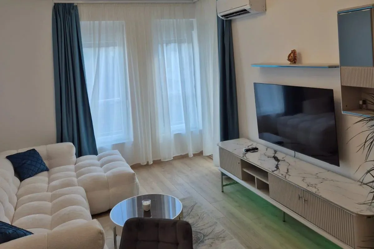Modern and bright living room with a sofa and television.