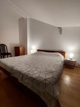 Spacious bedroom with a double bed, bedside lamps, and a wooden chest of drawers. - image 7