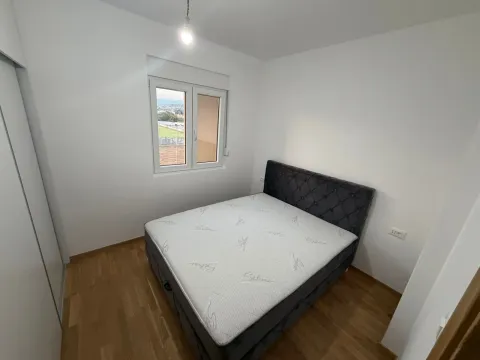 A bedroom with a double bed, white walls, and a window overlooking the surroundings. - image 12