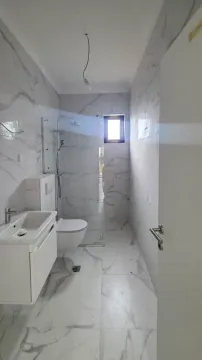 Novo opremljeno kupatilo sa bijelim mermernim pločicama i tuš kabinom. - image 3