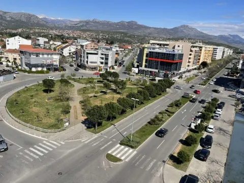 Pogled sa visine na gradski park, ulicu i planine u pozadini. - image 2