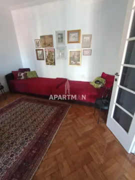 Dnevna soba sa crvenom garniturom, tepihom i slikama na zidu. - image 14