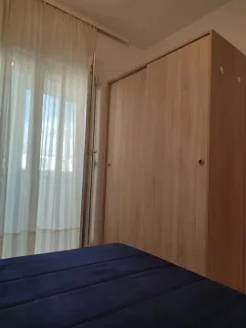 Spavaća soba sa velikim drvenim ormarom i krevetom. - image 3