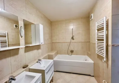 Bright bathroom with a bathtub, sink, and mirrors. - image 5