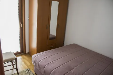 Jednostavna spavaća soba sa krevetom i drvenim ormarom. - image 8