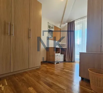Furnished bedroom with a wooden wardrobe, desk, and parquet flooring. - image 7