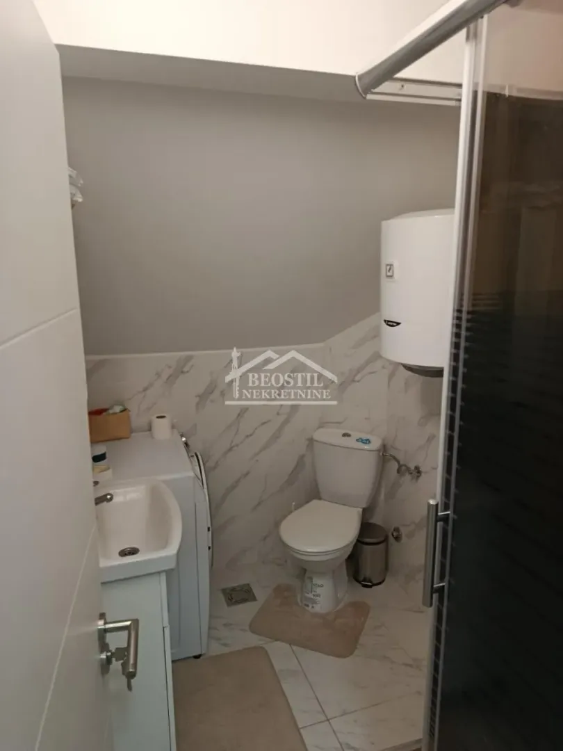 Manje kupatilo sa sanitarijama, tuš kabinom i bojlerom.