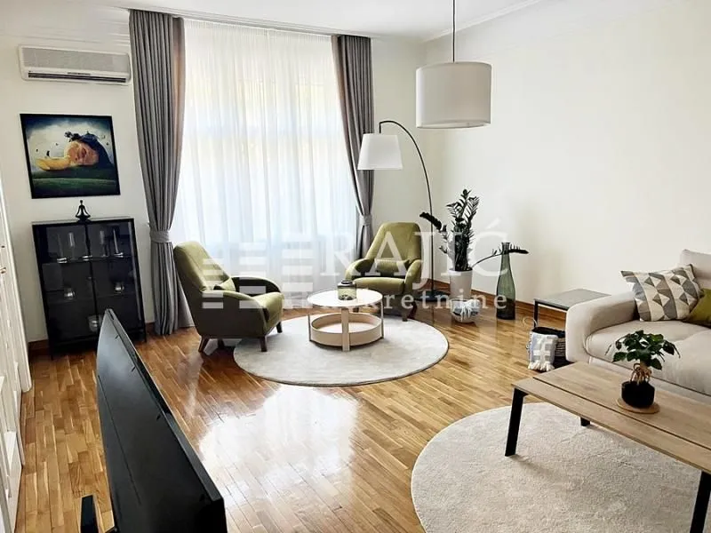 Spacious living room with seating area, armchairs and wooden flooring.