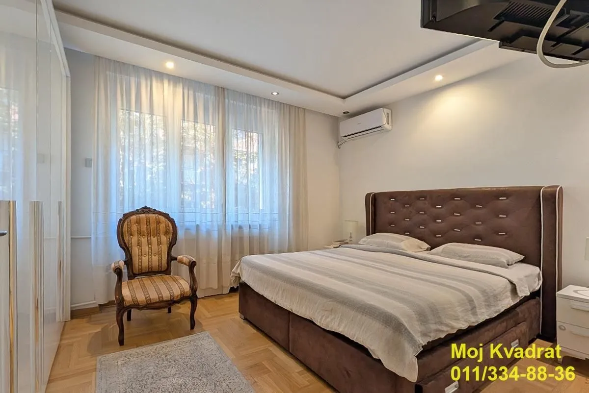Spavaća soba sa bračnim krevetom, foteljom i garderoberom.