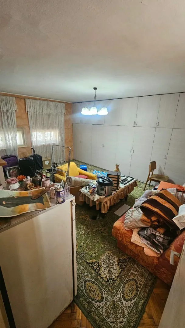 Dnevna soba sa namještajem i vidnim neredom.