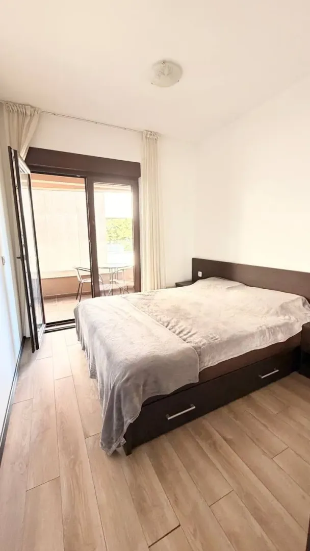 Spavaća soba sa bračnim krevetom i izlazom na terasu.