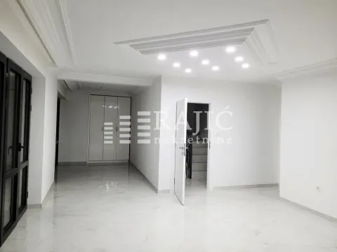 Empty bright room with marble flooring and a drop ceiling with recessed lighting. - image 3