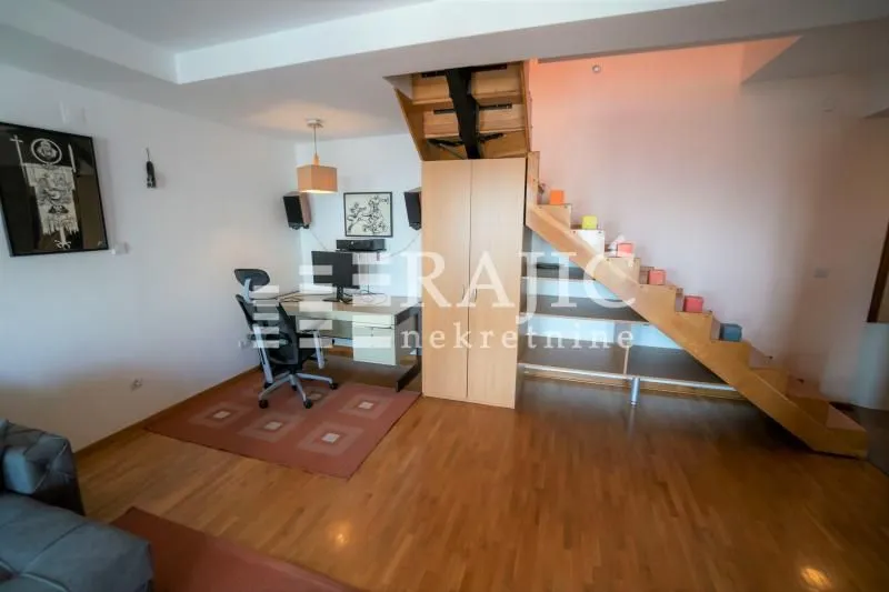 Living room with a work area and stairs.