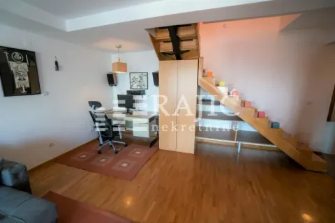 Living room with a work area and stairs. - image 7