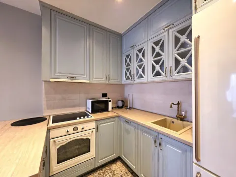Corner kitchen with light blue cabinets and built-in appliances. - image 5